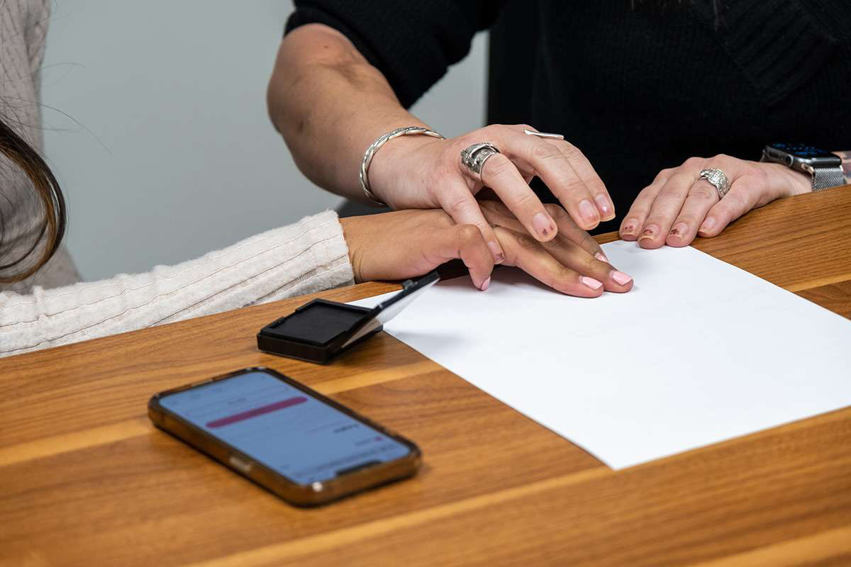 Person helping someone else do their fingerprints on a Utah BCI application